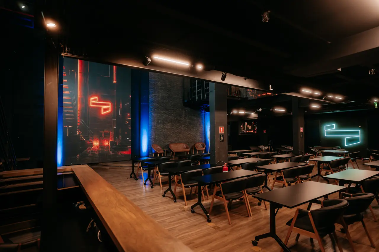Corredor de entrada com o palco e o neon ao fundo