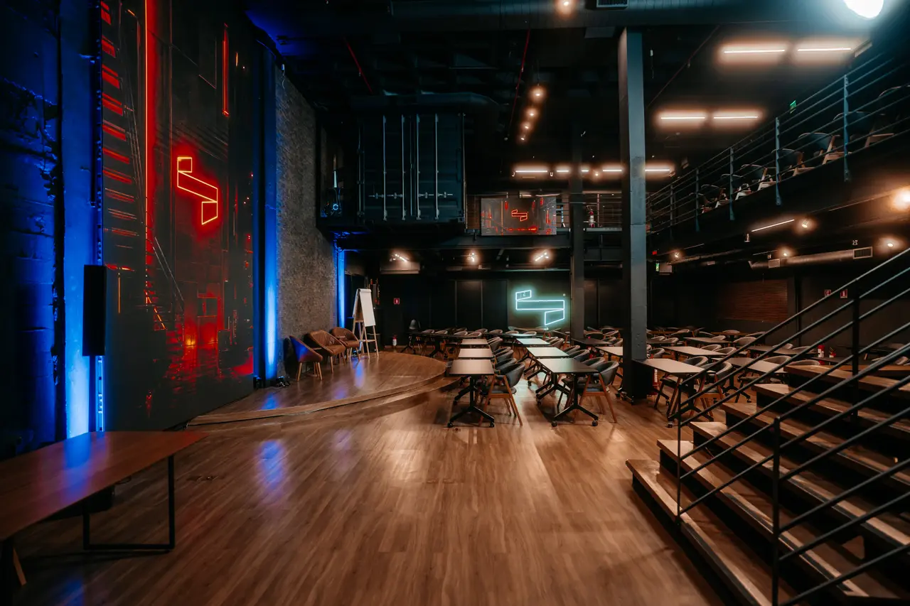 Salão da Casa com o neon vermelho no palco, as colunas de luz azul e o mezanino